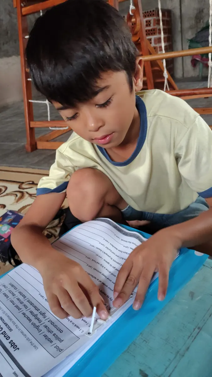 Anak membaca materi bahasa Inggris