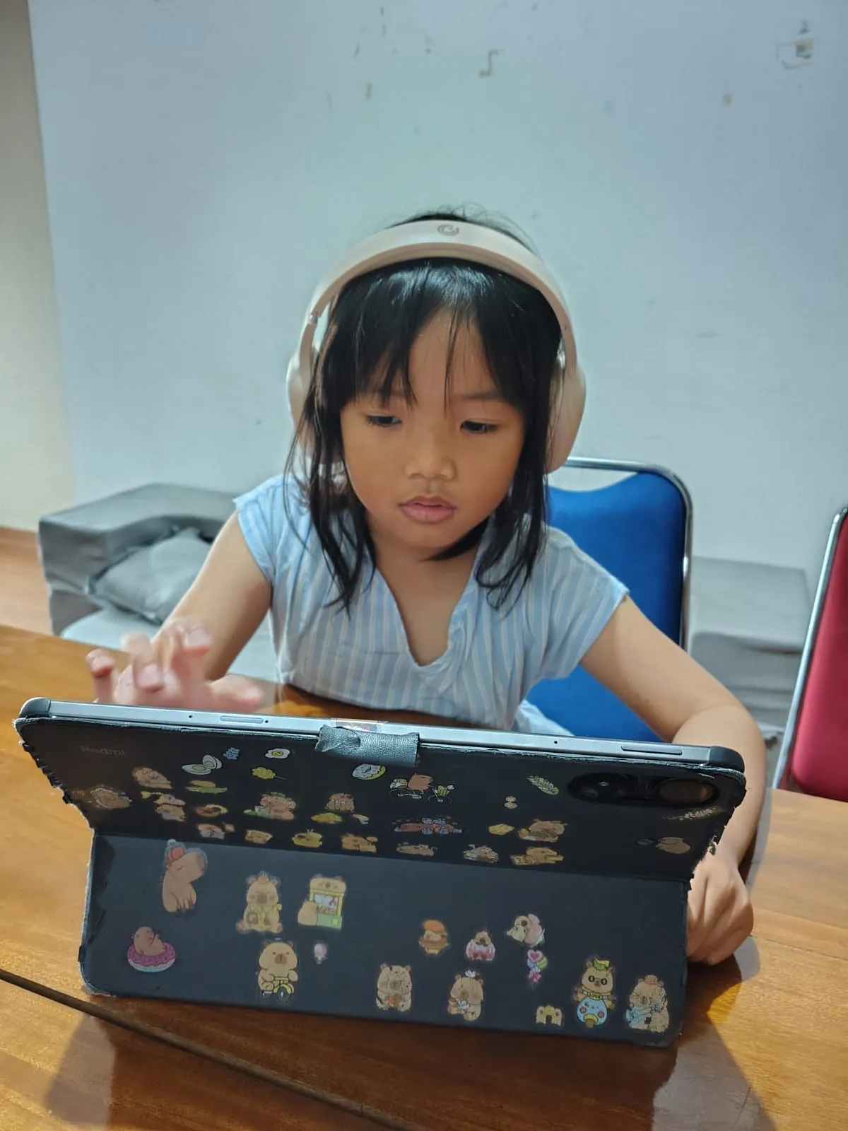 Anak mengikuti kelas bahasa Inggris interaktif dengan tablet