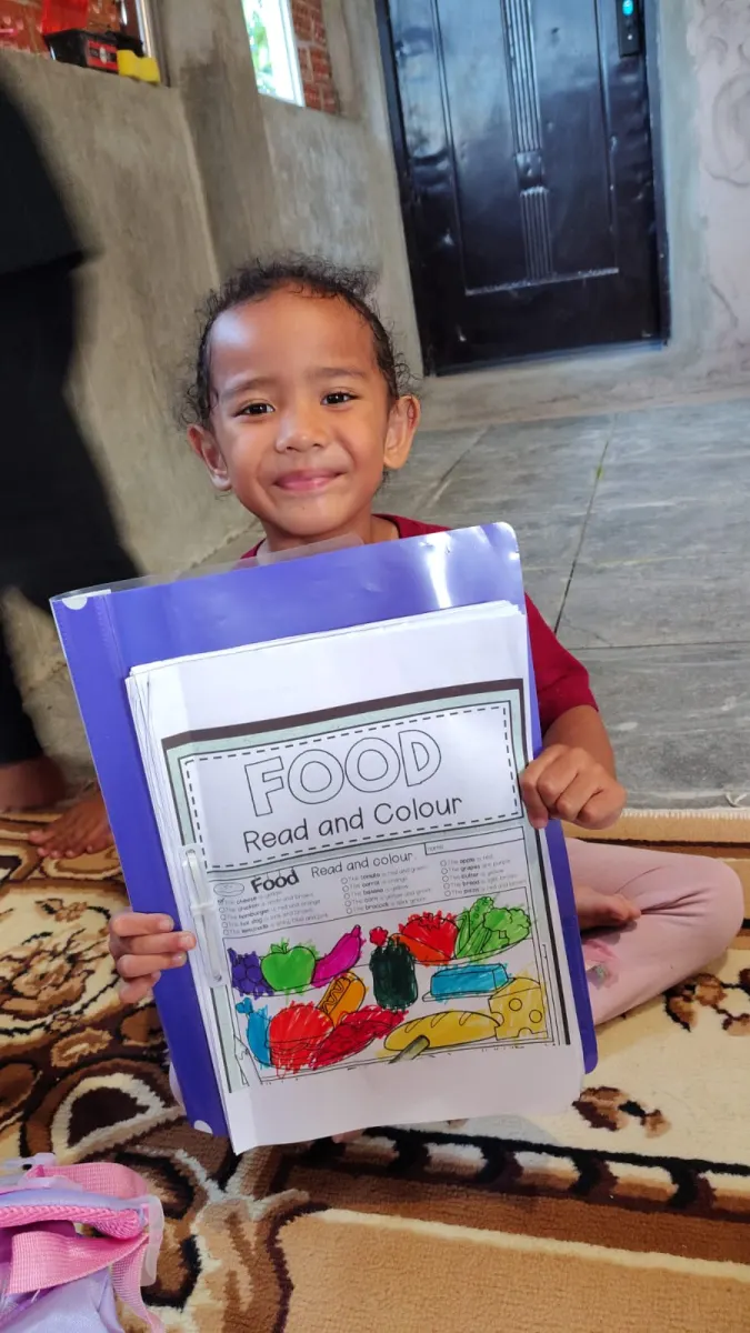Anak menunjukkan hasil worksheet berwarna